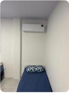 a bed in a room with a white wall at Pousada da Praça in Rosário do Sul +8 photos