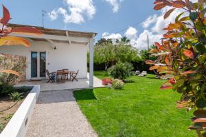 a garden with a patio and a table and chairs at Villa Leomaris in Torre dell'Orso