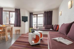 un soggiorno con divano e tavolo di Residence Antares - maeva Home ad Avoriaz