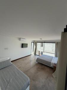 a bedroom with a bed and a large window at Vilaggio Magnolia in Cafayate