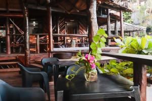 a table with a vase of flowers on it at Pousada Tiririca Surf in Itacaré