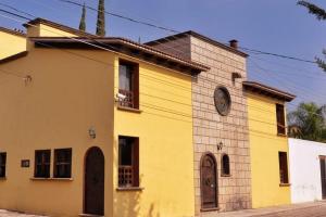 a yellow building with a clock on the side of it at Great location 5min from the center,10fromVINEYARD in Tequisquiapan