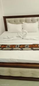 a bed with white sheets and pillows at Ocean & Beach kite Hotel in Kalpitiya