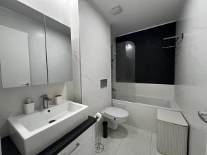 a white bathroom with a sink and a toilet at Nova Studio Bucharest #pool&parking in Ştefăneştii de Sus