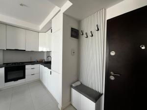 a kitchen with white cabinets and a black door at Nova Studio Bucharest #pool&parking in Ştefăneştii de Sus +5 photos