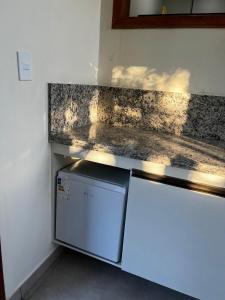 a white refrigerator in a kitchen with a counter top at quarto stantard 5 in Guarapari