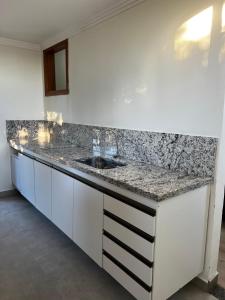 a kitchen with a sink and a counter top at quarto stantard 5 in Guarapari