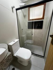 a bathroom with a toilet and a sink and a shower at quarto stantard 5 in Guarapari