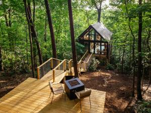 una terrazza in legno con una casa sull'albero nel bosco di Private Modern Treehouse Retreat in the Forest a Cross Plains
