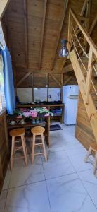 een keuken met een tafel en 2 krukken in een kamer bij Pousada PortoBello Praia do Rosa in Imbituba