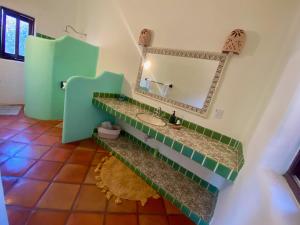 a bathroom with a sink and a mirror at Casa MoJo - Whole house 7BR, heated pool, WiFi in Sayulita +23 photos