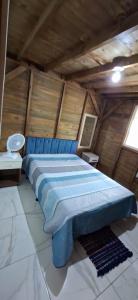 een slaapkamer met een blauw bed op een zolder bij Pousada PortoBello Praia do Rosa in Imbituba