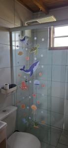 een badkamer met een douche met vis aan de muur bij Pousada PortoBello Praia do Rosa in Imbituba