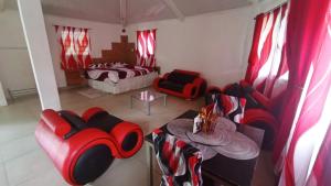 a living room with red chairs and a table at Ecotropicfarmhouse in Cerro Azul