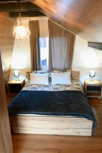 een slaapkamer met een groot bed met een kroonluchter bij Bungalov Aurora in Pale