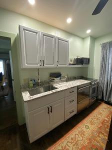 SpringfieldMust-See Okemo Mountain Resort的带白色橱柜和水槽的厨房