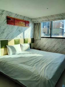 a bedroom with a large white bed with a window at 以琳文旅 in Zhongli +22 photos