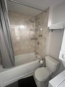 a bathroom with a tub and a toilet and a shower at Basement with 2 rooms in Ottawa +12 photos