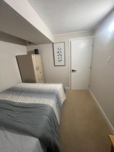 a bedroom with a bed and a white door at Basement with 2 rooms in Ottawa