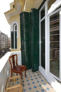 a chair sitting on a balcony with a window at Paradox in Thessaloniki