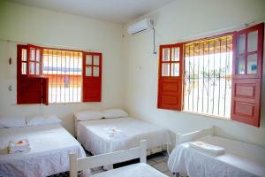 una stanza con due letti e finestre rosse di Casa Pamplona a Soure