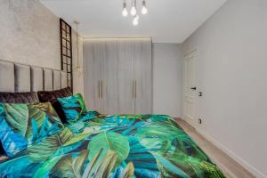 a bedroom with a bed with a colorful comforter at LOCUSDO Apartment No.31 in Mažeikiai