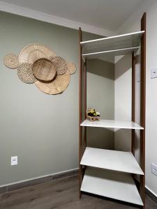 a shelf in a room with hats on the wall at Quarto standard 7 pousada village in Guarapari
