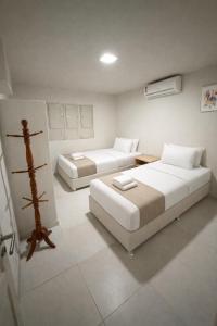 two beds in a white room with two beds sidx sidx sidx at Casa Canto do Mar in Maragogi