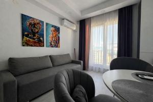 a living room with a couch and a table at Nova Studio Bucharest #pool&parking in Ştefăneştii de Sus