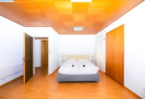 a bedroom with a white bed in a room at Piazza Grande House in Locarno