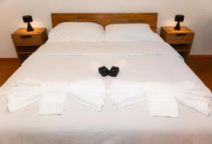 a white bed with a bow tie on it at Piazza Grande House in Locarno