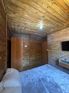 a room with a bed and a tv in it at Casa com vista para a natureza e piscina in Garopaba