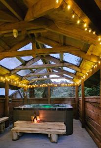 a wooden pavilion with a bench and lights on it at Hill Top Hideaway - Self Contained Guest Suite with Private Spa in Pukerua Bay