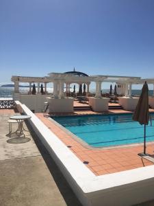 a swimming pool with a gazebo and the ocean at Playa Blanca Condo in Tijuana