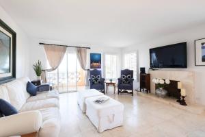 a living room with a white couch and a fireplace at Playa Blanca Condo in Tijuana