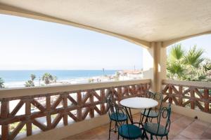 a balcony with a table and chairs and the beach at Playa Blanca Condo in Tijuana