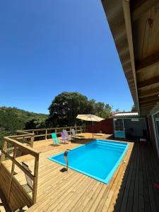 a swimming pool on the deck of a house at Casa com vista para a natureza e piscina in Garopaba