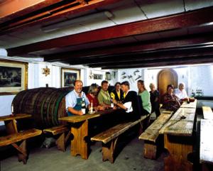 a group of people standing around a room with a barrel at Hotel Rebstock in Bruttig-Fankel