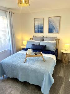 a bedroom with a large bed with a tray on it at Coastal Calm in Normanville