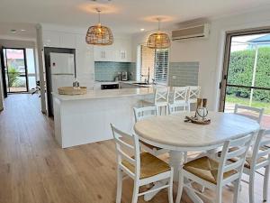 a kitchen and dining room with a table and chairs at Coastal Calm in Normanville