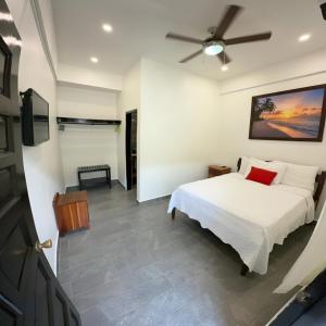 a bedroom with a bed and a ceiling fan at Serenade Hotel in Placencia