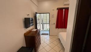 a room with a bedroom with a bed and a television at Serenade Hotel in Placencia