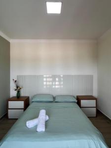 a bedroom with a bed with two towels on it at Quarto standard 9 in Guarapari