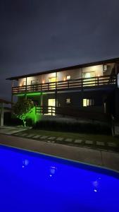 a building at night with the lights on at Quarto standard 9 in Guarapari