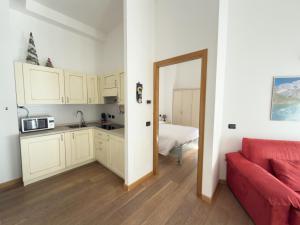 a kitchen and a living room with a red couch at Bilocale sulle piste da sci in Pila