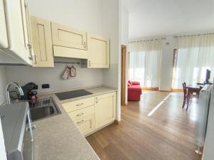 a kitchen with wooden floors and white cabinets at Bilocale sulle piste da sci in Pila +3 photos