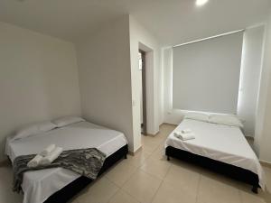 a bedroom with two beds and a large window at Casa HOTEL campestre TranKilandia in Rivera