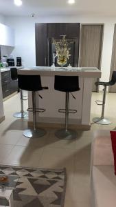 a kitchen with a island with two bar stools at Casa HOTEL campestre TranKilandia in Rivera