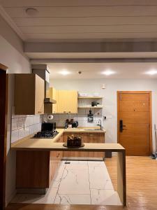 a large kitchen with wooden cabinets and a counter top at Designer 1 bedroom , self check-in , pool & sauna in Rawalpindi