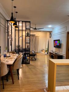 a living room with a table and chairs and a tv at Designer 1 bedroom , self check-in , pool & sauna in Rawalpindi